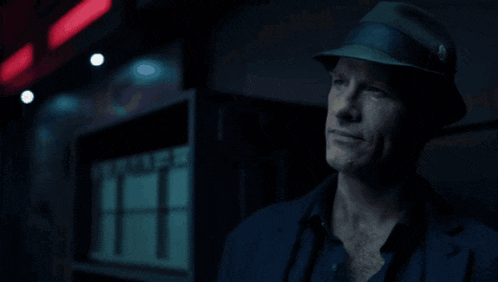 a man in a hat stands in front of a sign that says ' warehouse ' on it