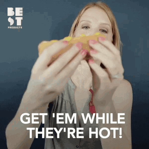 a woman eating a hot dog with the words get ' em while they 're hot on the bottom