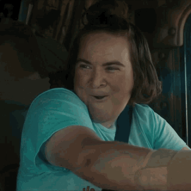 a woman in a blue shirt is smiling while driving