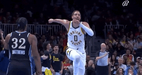 a basketball player for the indiana pacers is jumping in the air while celebrating a basket .