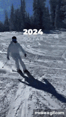a person skiing down a snow covered slope with the year 2024