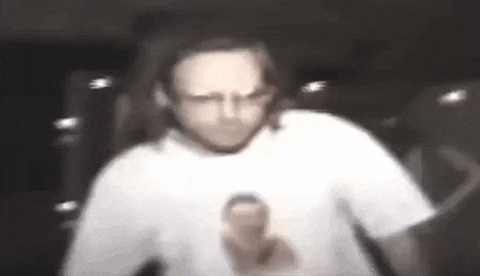 a blurry picture of a man in a white t-shirt holding a remote control .