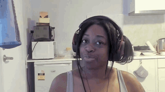 a woman wearing headphones in a kitchen has a sticker on her refrigerator that says ' a '