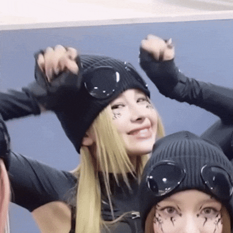 a woman wearing a black beanie and goggles is smiling for the camera