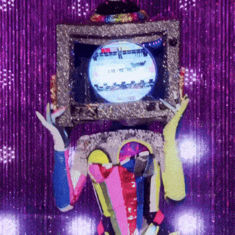 a person in a colorful costume is holding a television on their head ..
