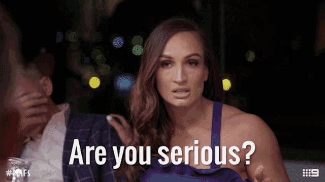 a woman in a purple dress is asking if she is serious