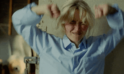 a woman with blonde hair wearing a blue shirt