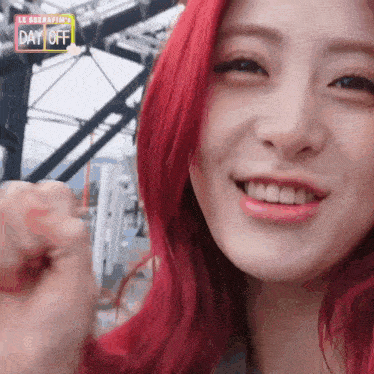 a close up of a woman 's face with red hair and a day off sign
