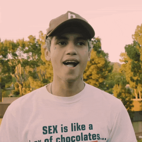 a man wearing a hat and a t-shirt that says sex is like a few chocolates