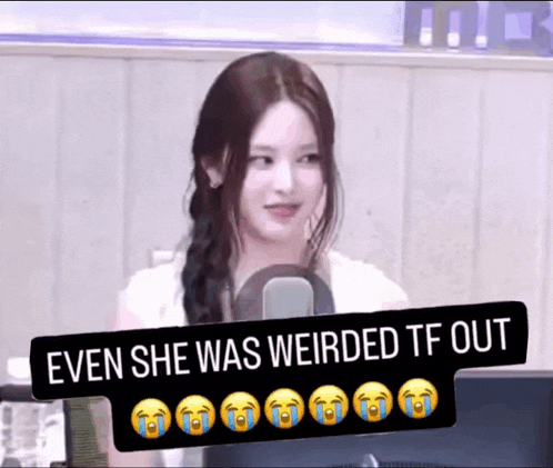 a woman is sitting in front of a microphone and a sign that says even she was weirded tf out