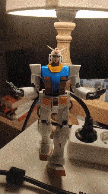 a blue and white robot is sitting on a table next to a lamp