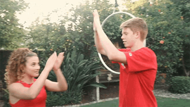 a boy and a girl are giving each other high fives