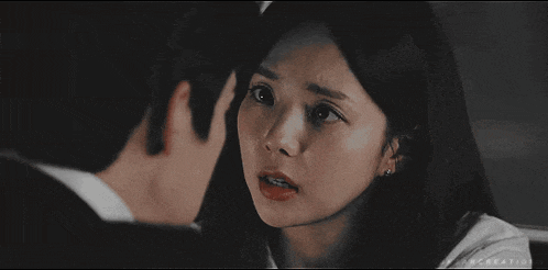 a man and a woman are looking at each other and the woman is making a funny face .