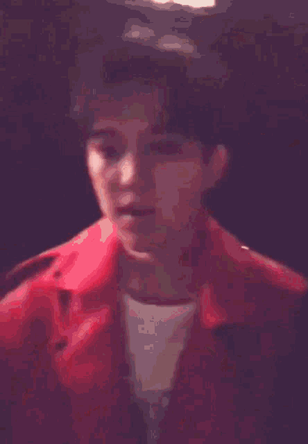 a person in a red jacket is holding a microphone and making a funny face .