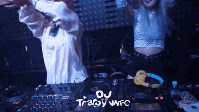 two women are playing music in a dark room with the words du tracy nfc on the mixer