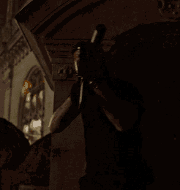 a man in a black shirt is holding a gun in his right hand