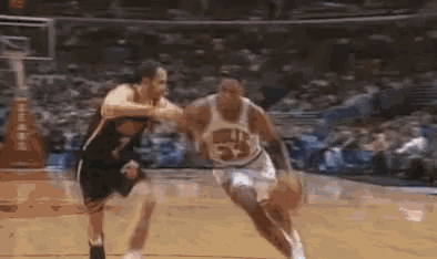 two men are playing basketball on a court .