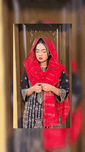 a woman wearing a red scarf and a black dress