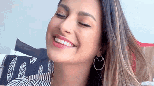 a close up of a woman 's face smiling with her eyes closed .
