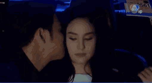 a man and a woman are sitting in the back seat of a car and kissing .