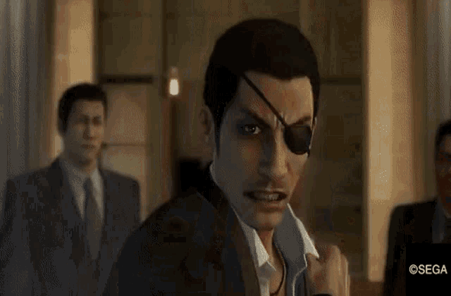 a man in a suit and eye patch is standing in front of a group of men in suits and ties .