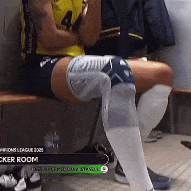 a soccer player sits on a bench in a locker room sponsored by fenerbahce medicalana istanbul