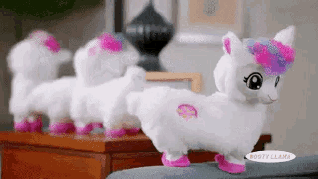 a stuffed llama with pink shoes is standing on a couch .