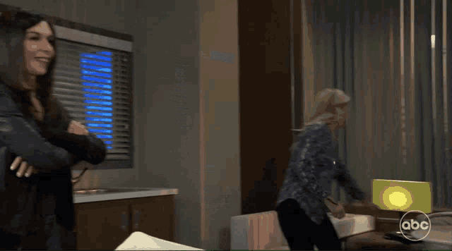 two women standing in a room with the abc logo on the bottom