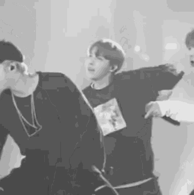 a black and white photo of a group of young men dancing on a stage .