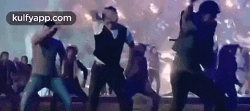 a group of people are dancing on a stage at a party .