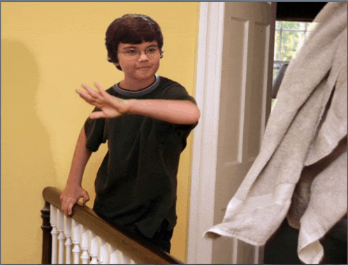 a young boy with glasses is standing on a staircase with his hand outstretched