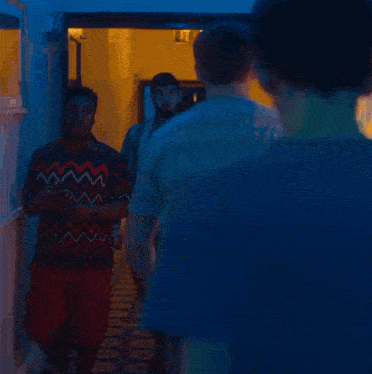 a group of people walking down a hallway with a sign on the wall that says exit