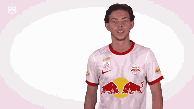 a man wearing a redbull jersey holds his fist up in the air