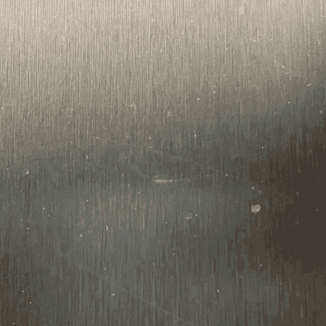 a close up of a stainless steel surface with a grainy texture