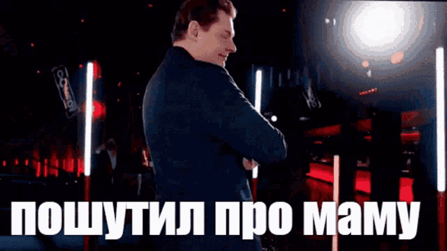 a man in a suit is standing in front of a screen that says " pouttil pro mamay "