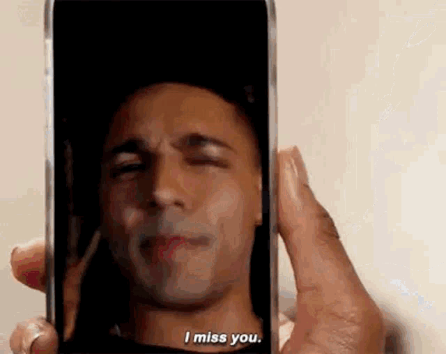 a person is holding a cell phone with a picture of a man 's face on it .