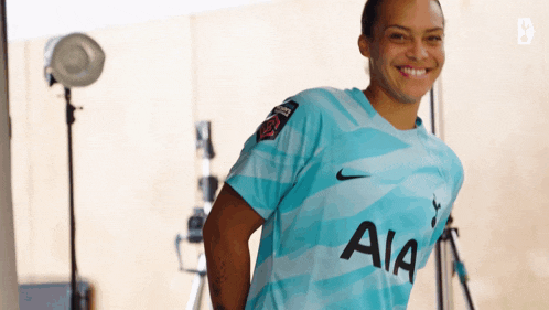 a woman wearing a blue aia shirt is smiling