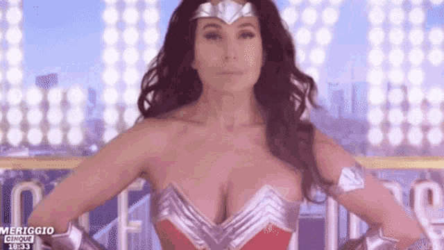 a woman in a wonder woman costume is standing in front of a crowd