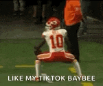a football player with the number 10 on his jersey is doing a trick on a field .