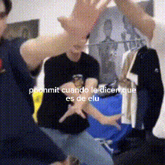 a man in a black shirt is giving a high five to another man in a black shirt .