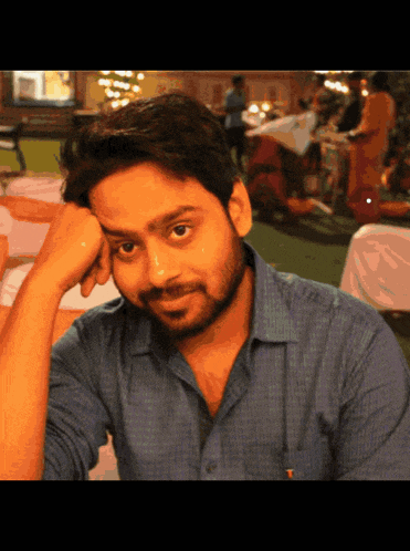 a man in a blue shirt with a pocket that says ' x ' on it