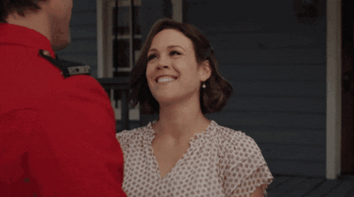 a man in a red shirt and a woman in a white shirt smile