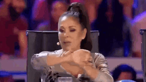 a woman is sitting in a chair making a funny face .
