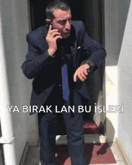 a man in a suit and tie talking on a cell phone
