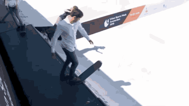 a man is riding a skateboard in front of an urban sports week sign