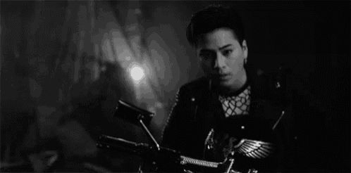 a man in a leather jacket is sitting on a motorcycle .
