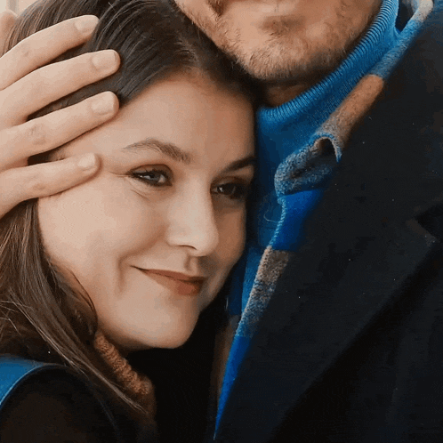 a close up of a woman 's face with a man holding her head
