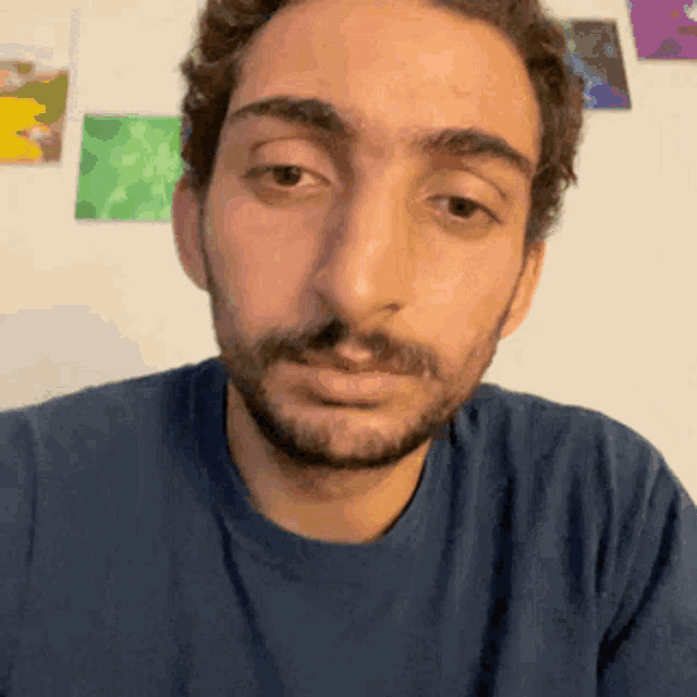 a man with a beard wearing a blue shirt