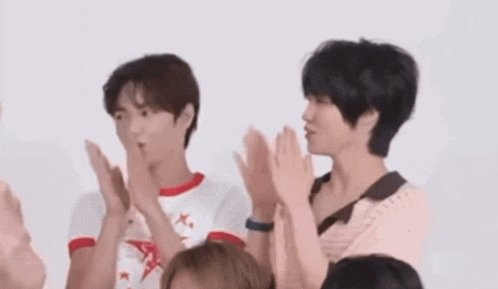 a group of young people are clapping their hands together .