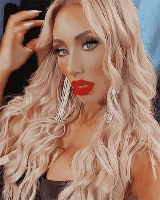 a woman with blonde hair and red lips takes a selfie